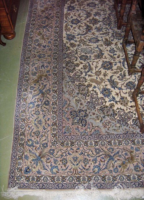 ISFAHAN old.Beige ground with a grey central medallion and corner motifs, the entire carpet is finely patterned with trailing flowers, palmettes and animals, grey border, stained, 385x265 cm.