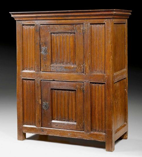 HALF-HEIGHT CABINET,Gothic and later, France. Shaped and finely carved oak with linen fold and frieze. With two doors, iron mounts and locks. 105x49x120 cm. Provenance: Zurich private collection