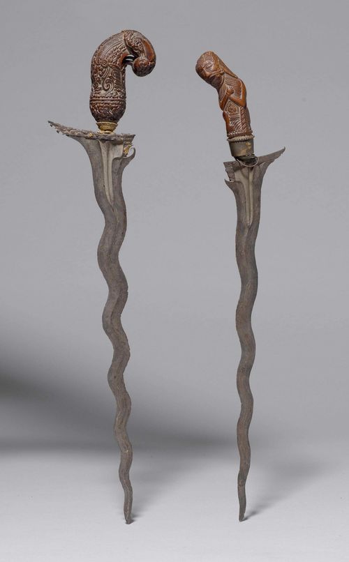 TWO IRON KRIS WITH HANDLES OF CARVED WOOD. Indonesia, Lengths 44.5-46.5 cm. (2)