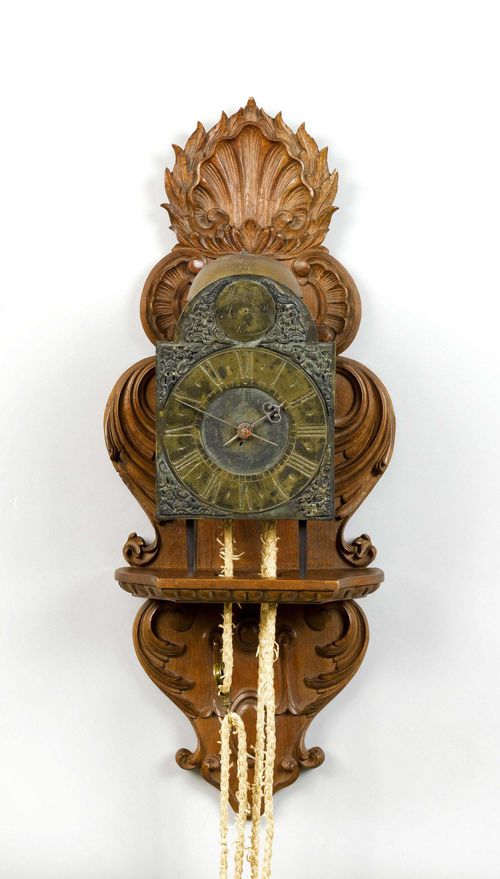 IRON CLOCK,England, 18th century. The dial inscribed WILLIAM JOURDAIN LONDON. Open case. Brass dial ring. Movement with anchor escapement striking the 1/2-hour on bell.  H 34 cm. On a later, carved wooden console. Pendulum, later.