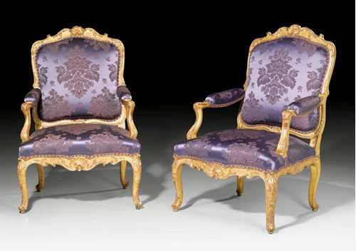 PAIR OF LARGE FAUTEUILS "A LA REINE",Louis XV, from a Paris master workshop, circa 1735/45. Richly carved giltwood with rocaille, leaves and frieze. With violet silk covers with flowers and leaves and decorative nail work. 72x59x48x103 cm. Provenance: from a highly important European private collection