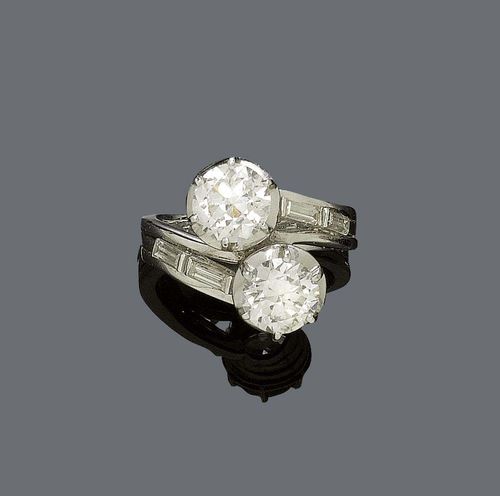 DIAMOND RING, ca. 1950. White gold 750. Decorative crossover ring, set with 2 old european cut diamonds of ca. 1.40 ct ca. SI2 / I-J, and ca. 1.50 ct ca. SI2/ I-J, respectively. The ring shoulders are decorated with 4 baguette-cut diamonds weighing ca. 0.40 ct. Size 54.