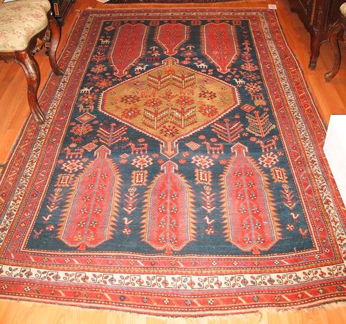 GASCHGAI antique, dated 1927.Dark blue central field with a green central medallion, the ends are decorated with bulky trees of life in red, the entire carpet is patterned with stylized depictions of plants and animals, triple stepped border in red and white, slight wear, 260x150 cm.