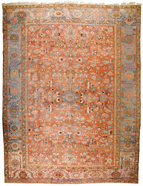 HERIZ antique.Dusky pink central field, patterned throughout with stylized plant motifs in light blue and yellow, blue border, signs of wear, 390x290 cm.