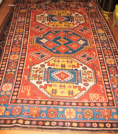 LORI PAMPACH antique.Rust coloured ground with three medallions in white, blue and green, the entire carpet is geometrically patterned with star motifs and animals, blue border, good condition, 220x140 cm.
