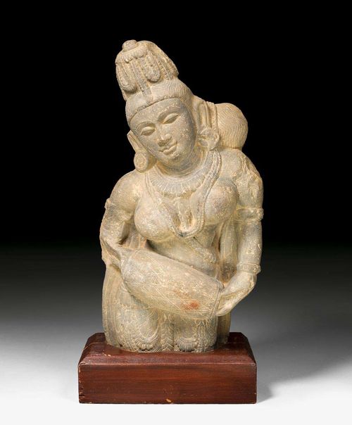 A GREY STONE BUST OF A YAKSHI HOLDING A DRUM. Central India, ca. 11th c. Height 45 cm