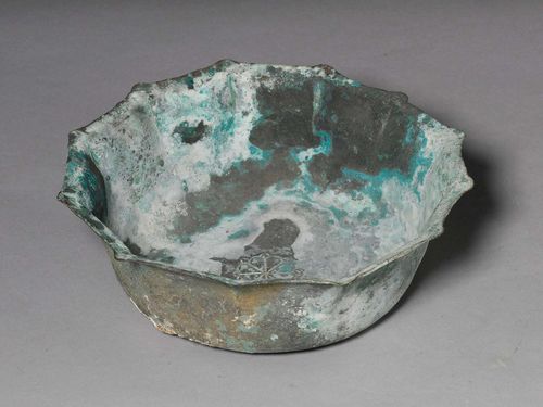 A BRONZE BOWL WITH A WHITE-GREEN PATINA AND AN INCISED FLORAL DESIGN. Iran, Khorasan, ca. 12th c., diameter 22.5 cm.