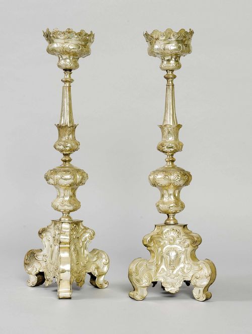 PAIR OF ALTAR LAMPS,late Baroque. Sheet silver on a wooden core. Retracted shaft with large drip pan and spike. Walls decorated with chased leaves. On a curved plinth. H 71 cm.