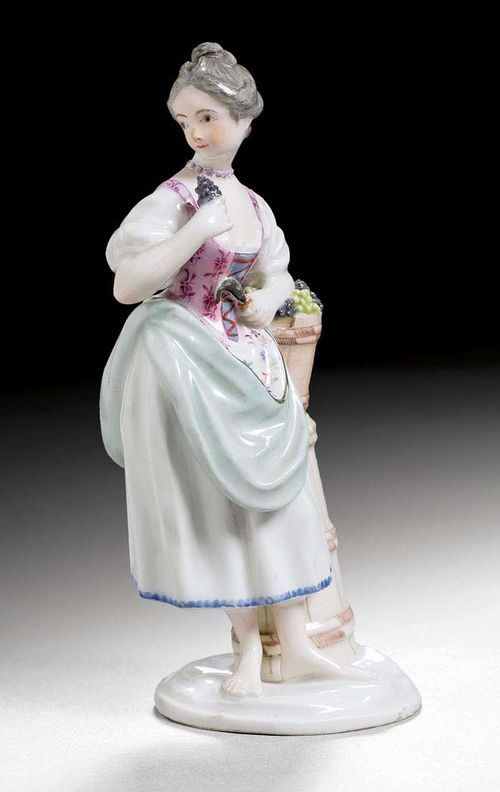 GIRL WITH GRAPES, Zürich, circa 1785.Model by Gabriel Klein, probably from a series based on the seasons, the original form 154 described as 'Herbst St 5'. Underglaze blue Z mark and 2 dots, K : I incised . H 13.5cm. Neck and nose restored. Provenance: private collection, Switzerland