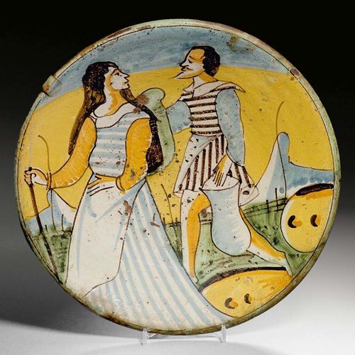 DISH WITH PAIR OF WALKERS, Montelupo, circa 1700.Painted in yellow, green and blue. D 31cm. Slight flaking on the glaze