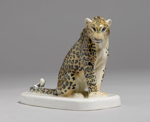 MODEL OF A LEOPARD,Meissen, modern. Seated on an oval base, with naturalistic light brown fur with black spots. Underglaze blue sword mark, model number B.247., press number. 19.5 x 13.7 cm.