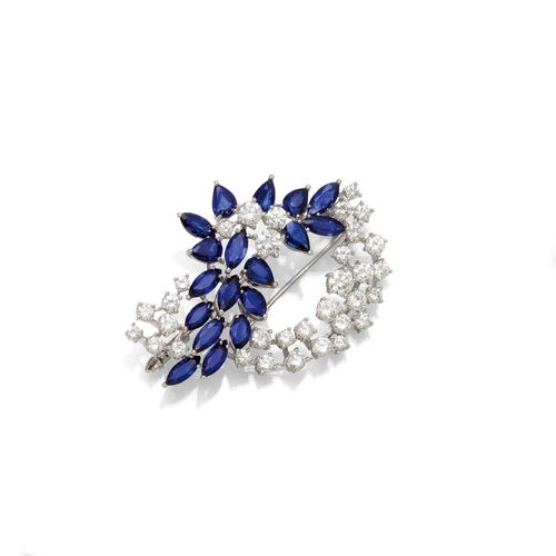 SAPPHIRE AND DIAMOND BROOCH, ca. 1950. White gold 750. Designed as a flower, set with 18 marquise-cut and pear-cut sapphires, weighing ca. 8.00 ct, and 33 brilliant-cut diamonds, weighing ca. 5.40 ct. L ca. 5.2 cm. With case and copy of the catalogue description from the 1980s.