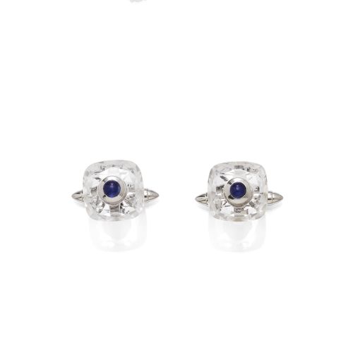 ROCK CRYSTAL AND SAPPHIRE CUFF LINKS. White gold 585. Each of 1 facetted, slightly square rock crystal, the centre set with 1 sapphire cabochon. Sapphire weight ca. 0.80 ct in total.