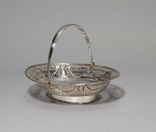 BASKET WITH HANDLE,Dublin, late 18th century. Maker's mark: RW. Oval with smooth base. Pierced walls decorated with festoons. Hinged handle engraved with crowned monogram. Some repairs. L 33.5 cm, 820 g.