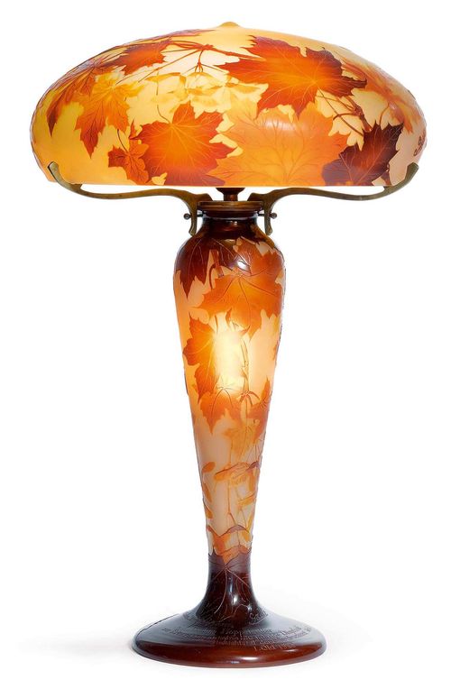 EMILE GALLE TISCHLAMPE, c. 1910 Yellow glass overlaid in orange and brown with etched decoration. Signed Gallé. The base with small chip and the foot with engraved dedication. H. 60 cm.