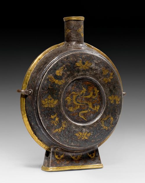 A GOLD- AND SILVER-DAMASCENED IRON MOON FLASK WITH BRASS BORDERS FOR "CHANG" BEER. Tibet, ca. 18th c. Height 37 cm.