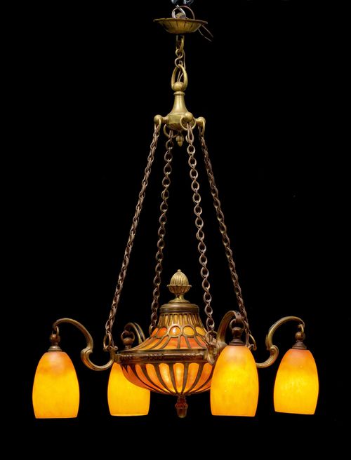DAUM NANCY CHANDELIER, ca. 1920. Orange glass with bronze mount. Designed as an oil lamp with 4 bell-shaped shades. Signed Daum Nancy. H 85 cm. D 63 cm.