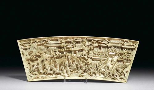 IVORY CARVING in the shape of a fan. Finely-worked depiction of a palatial estate. A senior civil servant holding a hearing and his entourage are seated on a terrace which can be accessed from a broad stairway. On the left, a delegation of visitors is leaving, while a new guest is being shown the way to the staircase. On the back: Qianlong mark. Wooden stand added. China, around 1800, B 35 cm.