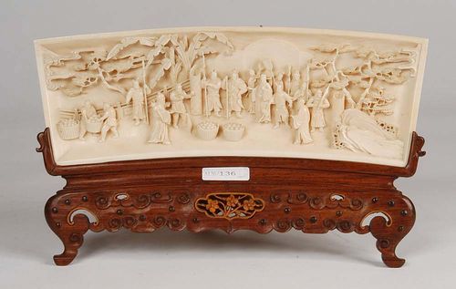 FINE IVORY CARVING in the shape of a fan. A civil servant with armed guards and two fan bearers are gathered in a garden. A Taoist hermit, recognizable due to his pumpkin gourd, is instructing his helpers on bearing baskets of fruit. In the background, pines and banana trees. Wooden stand. China, around 1800, W 26.5 cm. Very well preserved.