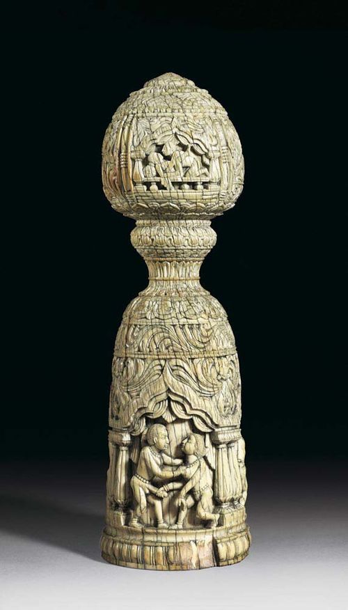 EROTIC IVORY CARVING, originally part of a piece of furniture (bed or table post), since two apertures can be seen on the top part. Bell-shaped body with bud-shaped fixture on top. On the bottom and on the handle: carved niches showing erotic scenes surrounded by fine floral carvings. India, 18th/19th century. H 25 cm. Two parts missing on the lowest border, one woman's arm damaged.