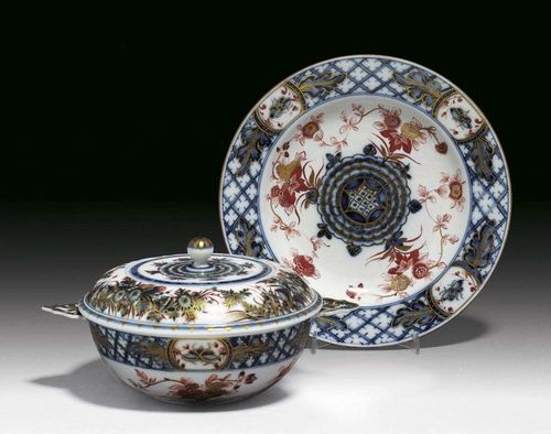 DOUBLE-HANDLED BOWL WITH COVER AND STAND, Meissen, circa 1730. Painted in Imari style in underglaze-blue and iron-red picked out in gilding, with Indian flowers and lattice work, crossed swords in underglaze-blue to inside of bowl and back of the stand. Bowl 16cm, stand 22cm. Provenance: Private collection, Basel.