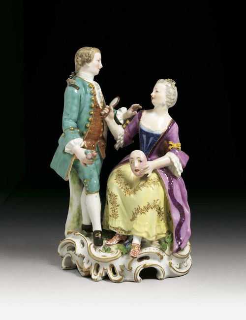 GROUP OF A LADY AND A GENTLEMAN, Meissen, circa 1763-74. She seated with a mask in her left hand, a mirror in her right, the gentleman standing to her right, his hand reaching out to her, crossed swords and dot in underglaze-blue, impressed B.S.z.94z., 20cm, small restorations.