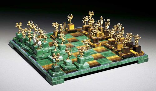 GOLD AND GEMSTONE CHESS GAME. Yellow gold 750. Exclusive chess game consisting of 32 decorative cherub figures on malachite and tiger eye bases. As pawns: 16 cherubs with arched bows. As castles: 4 cherubs carrying a castle adorned with 1 brilliant-cut diamond. As bishop: 4 cherubs carrying an enameled standard. As knight: 4 cherubs riding hobbyhorses. The King and Queen are wearing enameled ermine cloaks, their crowns and scepters are set with jewels. Decorative chess board, fields are malachite or tiger eye, surrounded by a sodalite band, rim and bases in malachite. Board size is 29 x 29 cm. Average height of the cherubs ca. 5.5 cm, incl. the base.