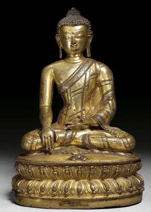 GILT COPPER ALLOY FIGURE OF BUDDHA SHAKYAMUNI. With remains of blue colour in hair. Tibet, 17th century.  H 21 cm.