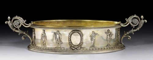 OVAL JARDINIERE. In Empire style. Germany, 19/20th century. Oval with flared gadrooned edge, the foot with egg and dart pattern, the sides with applied depiction of the muses. Brass liner for flowers.