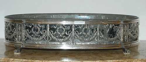 OVAL JARDINIERE. France, 19th century. Silver plated. The mark Christofle. Pierced form with floral festoons, columns and ribbons, set on claw feet. With metal liner. 50x31 cm.