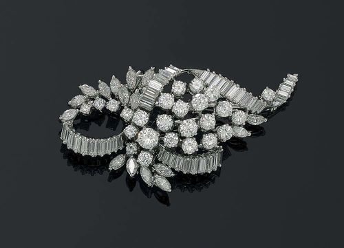 DIAMOND BROOCH, ca. 1950. White gold 750. Classic and elegant brooch in the shape of a stylised leaf, set with 24 brilliant-cut diamonds as well 16 diamond navettes, additionally decorated with a band motif, set with 43 baguette-cut diamonds. Total weight of the brilliant-cut diamonds and diamonds ca. 8.16 ct.
