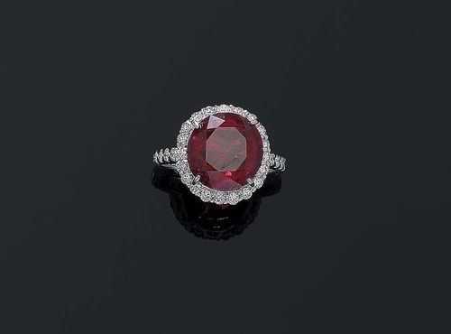RUBY AND BRILLIANT-CUT DIAMOND RING. White gold ca. 670. Classic-fancy ring, top set with 1 fine-quality orange-red ruby of 6.61 ct. in a brilliant-cut diamond surround. The shoulders are additionally decorated with 14 brilliant-cut diamonds. Total weight of the brilliant-cut diamonds ca. 0.68 ct. Size 52. With Gem Report No. 112291 from the Stalwart Gem Laboratory, July 2006.