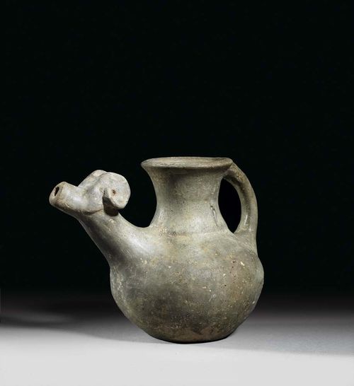 JUG, Iran, in the style of the 8/7 century BC Grey clay. The spout in the form of a ram's head. H 15.5 cm.