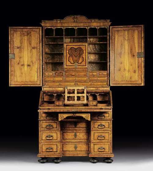 BUREAU CABINET, Baroque, probably Hanover circa 1710. Walnut, burlwood, birch and local fruitwoods, finely inlaid with ribbonwork, cartouches and frieze. Fall-front writing surface over 3 drawers and 4 smaller lateral drawers, the upper two drawers acting as supports for the writing surface, fitted interior with leather lined sliding ledge, compartments and drawers, recessed double door upper section, also with fitted interior, fine bronze mounts and drop handles 100x61x95x225 cm. Provenance: from a Roman collection.