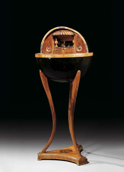 GLOBE TABLE, Biedermeier, probably after designs by J. PÖSSENBACHER (Joseph Pössenbacher, active circa 1810/30), Vienna circa 1815. Elm, cherry, yew and various fruitwoods in veneer and finely inlaid with fillets and frieze also partly ebonised. Hinged globe on 3 scrolled legs, architectural style fitted interior with mirror-lined central compartment between canopy and stepped drawer, flanked by cylindrical drawers. The lower section with removable compartment and secret drawer. D 43 cm, H 89 cm. Provenance: private collection, Germany