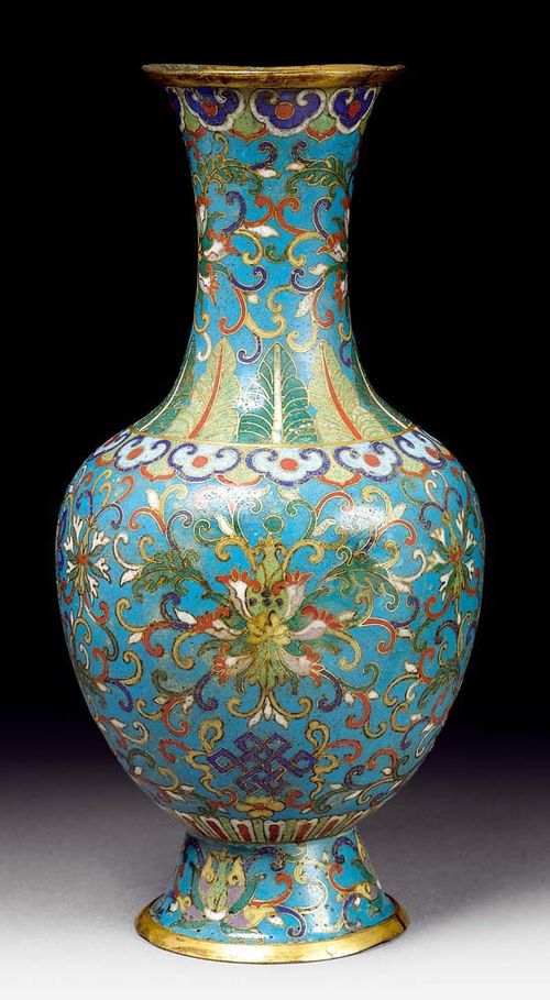 SMALL BALUSTERVASE.China, 18th century. H 18.5 cm. Cloisonné decoration of lotus tendrils and Buddhist symbols on a turquoise background, framed by Ruyi bands. There is an additional collar of banana leaves around the neck.  The base and the rims are gilded. Two minor restored dents.