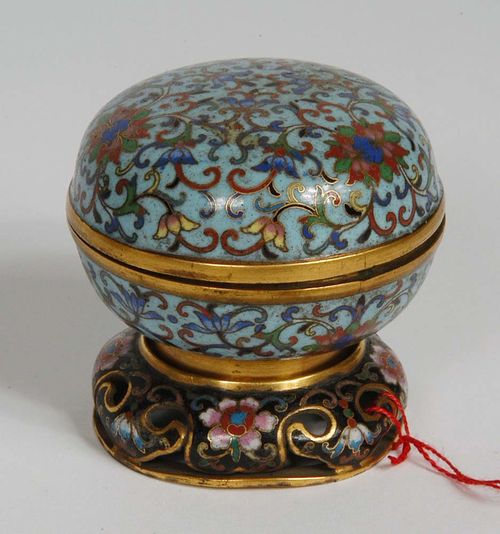 ROUND CONTAINER WITH LID on a gilded stand. Fine lotus tendrils in cloisonné enamel technique on a light-blue background with gilding. Interior in dark turquoise. China, 18th/19th century. D 6.2 cm. Base chipped. Berti Aschmann Collection