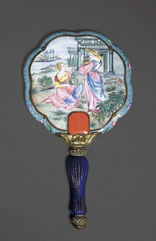 HAND MIRROR with a Cantonese enamel decoration: the border is painted with floral tendrils on turquoise background; finely decorated verso in Greco-Antique manner depicting two ladies in front of buildings with pillars and a river scene. The mirror is reinforced with a baluster-shaped handle and square coral tiles. China, 18th century. L 26 cm. Slight damage due to aging.