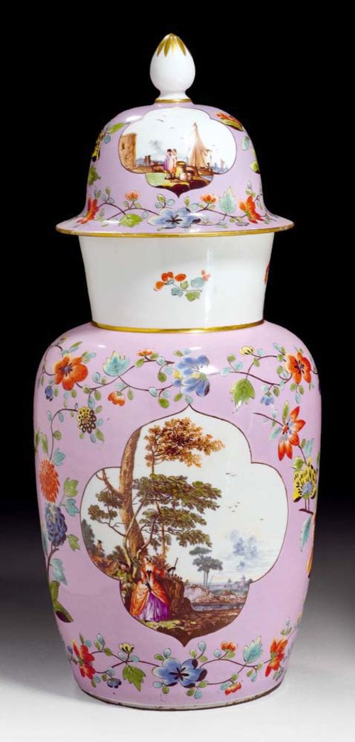 AUGUSTUS REX COVERED VASE, Meissen, circa 1735.Painted on both sides with landscapes with courtly figures and buildings in the background, against a pink ground with polychrome Indianische Blumen an insect and floral garland. The domed lid similarly decorated with landscape and merchant scenes. Underglaze blue mark AR. H 42.5cm. The lid non-matching and restored on the edge. Provenance: from an important private collection, Basel