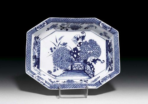 BASIN, Meissen, circa 1740. Octagonal form, painted in underglaze-blue in Chinese style with chrysanthemum and peony flowers in a fenced garden, crossed swords and K in underglaze-blue, impressed numeral 26, 32,5x25cm. Slightly chipped.