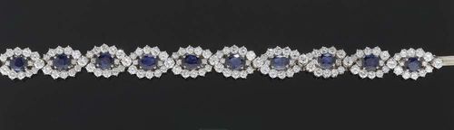 SAPPHIRE AND BRILLIANT-CUT DIAMOND BRACELET, FRIEDRICH. White gold 750. With 10 oval sapphires totaling ca. 10.00 ct, between two wave-shaped crossed rows of 130 brilliant-cut diamonds totaling ca. 16.00 ct. L ca. 17.5 cm.