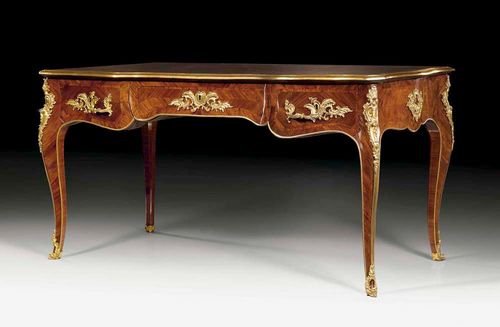 BUREAU-PLAT, Louis XV, attributed to G. JOUBERT (Gilles Joubert, 1689-1775) Paris circa 1750/60. Tulipwood and rosewood veneer inlaid with reserves and fillets. The shaped top lined with green gold stamped leather and edged in bronze. The front with broad central drawer flanked by 2 drawers each side. The same but sham arrangement verso. With exceptionally rich matte and polished gilt bronze mounts and sabots. Restored and with alterations. 150x76x77 cm. Provenance: Château de Vincy, West Switzerland.