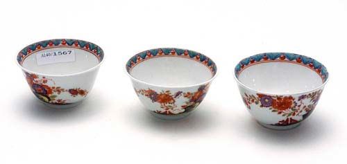 FOUR SMALL CUPS WITH "INDIANISCHEN BLUMEN", Meissen, circa 1735-40.Each painted with chrysanthemums in iron red and purple, with stylised foliate border on inside of rim. Underglaze blue sword mark, potter's mark / on 3 cups. Provenance: from a private collection, Solothurn