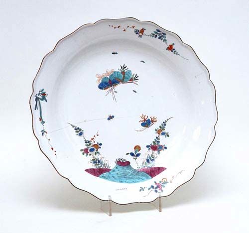 LARGE DISH WITH KAKIEMON DECORATION, Meissen, circa 1735.'Alter Ausschnitt', painted with a rock, Indianische Blumen and butterflies. Underglaze blue sword mark. D 43cm, long hair crack through the centre. Provenance: from a private collection, Solothurn