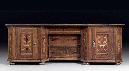 UNUSUAL DESK, Baroque, Switzerland, incorporating old elements. Walnut inlaid with flower vases and grotesques in rectangular reserves. The front central section with three recessed drawers, flanked on each side by a door. Iron mounts and lock. 2 keys. 230x63x80 cm.