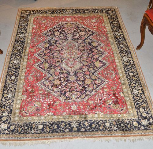 GHOM SILK old.The blue central medallion is set on an old rose ground patterned with floral motifs. With a black border. Good condition, 140x215 cm.