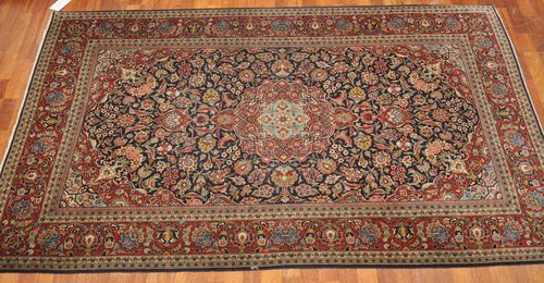 KESHAN old.With a blue central field and red medallion, lavishly patterned with trailing flowers and palmettes and with a red border. Good condition, 135x210 cm.