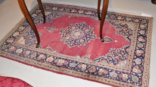 KESHAN old.With a red ground, floral central medallion and dark blue border. Slightly worn, 110x160 cm.