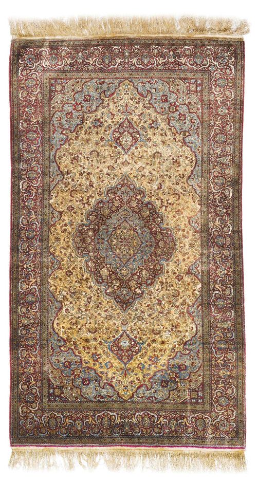 KESHAN SILK antique. The floral central medallion is set on a beige ground and with light blue corner motifs. The entire carpet is finely patterned with trailing flowers and palmettes. With a violet border. Good condition, 129x212 cm.