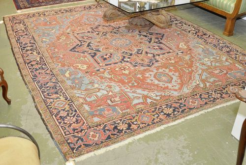 HERIZ old.Red ground with light blue corner motifs and a black central medallion, typically patterned, black edging, strong signs of wear, 260x335 cm.